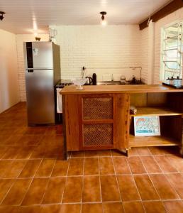 a kitchen with a stainless steel refrigerator and a counter at Cabana Rosa na mata in Imbituba +13 photos