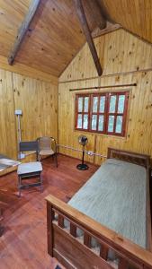 a bedroom with a bed in a wooden cabin at Cabaña Natural Del Bosque in Victoria