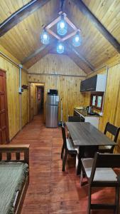 a dining room with a table and a kitchen at Cabaña Natural Del Bosque in Victoria