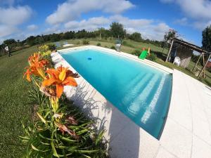 a large blue swimming pool with a flower next to it at Cabaña Natural Del Bosque in Victoria