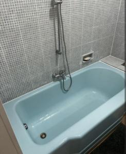 e bagno con vasca blu e doccia. di T2 de 70 m2 au cœur de Sète a Sète