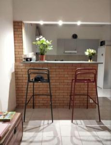 una cucina con due sgabelli da bar e un bancone con due sedie di T2 de 70 m2 au cœur de Sète a Sète