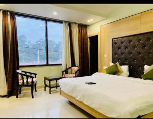une chambre avec un grand lit et une grande fenêtre dans l'établissement Hotel November 1 Min from Zirakpur bus stand, à Zirakpur