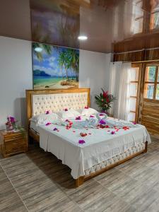 een slaapkamer met een groot bed met bloemen erop bij HOTEL BAHÍA PINORROA in Capurganá