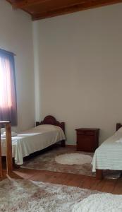 Cette chambre blanche dispose de deux lits et d'une fenêtre. dans l'établissement Retama, à Río Gallegos 4 autres photos