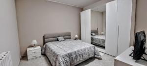 a white bedroom with a bed and a mirror at La Dimora del Colle in Palo del Colle +20 photos