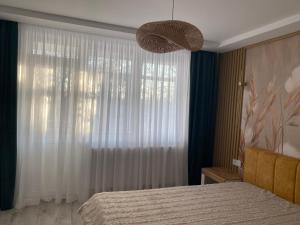 a bedroom with a bed and a large window at Central Nest in Tecuci
