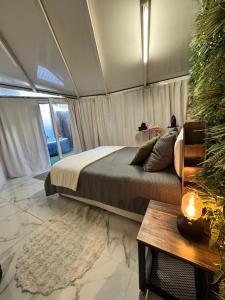 een slaapkamer met een bed en een tafel bij Modern suite with private Jacuzzi garden in Toulon