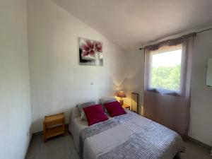 ein Schlafzimmer mit einem Bett mit zwei roten Kissen in der Unterkunft Appartement T2 Mezzanine avec Terrasse Proche Lac - Animaux Acceptés ! - FR-1-379-27 in Vieux-Boucau-les-Bains