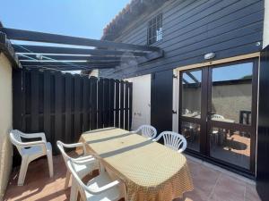 eine Terrasse mit Tisch und Stühlen auf einem Deck in der Unterkunft Appartement T2 Mezzanine avec Terrasse Proche Lac - Animaux Acceptés ! - FR-1-379-27 in Vieux-Boucau-les-Bains