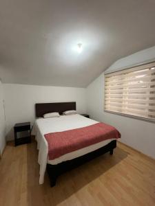 una camera da letto con un letto grande con una coperta rossa di Casa Dichato Equipada a Dichato