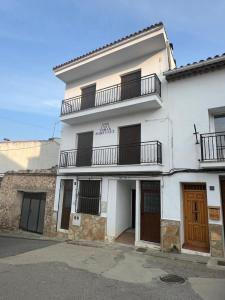 een wit gebouw met een balkon erboven bij La Casita in Tejadillos