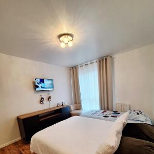 Schlafzimmer mit einem Bett und einem TV an der Decke in der Unterkunft Studio ALPHA - 3min by train to Disneyland OR 30min walk - 5min walk to "Val d'Europe" train station in Montévrain