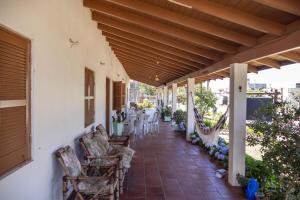 a porch with chairs and tables on a house at Pousada recanto do mar torres Itapeva norte in Torres