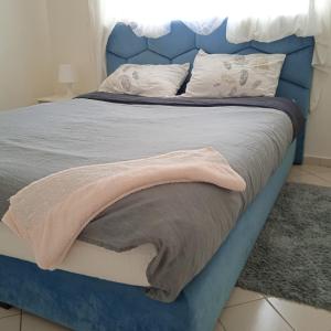 een blauw bed met een blauw hoofdeinde en kussens bij Séjour idéal in Rabat