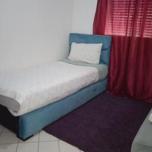 een bed in een kamer met een rood gordijn bij Séjour idéal in Rabat