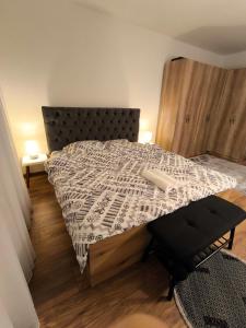 a bedroom with a bed with a black and white comforter at Veneto Apartment in Prishtinë