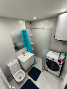 a small bathroom with a toilet and a sink at Veneto Apartment in Prishtinë