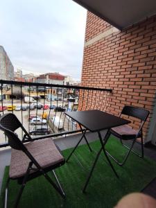 a table and chairs on a balcony with a view of a parking lot at Veneto Apartment in Prishtinë