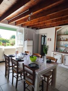 a dining room with a table with chairs and a kitchen at Gîte menthe à l'eau in Ciadoux