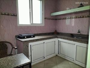 een keuken met witte kasten, een gootsteen en een raam bij HOTEL 7DAYS DAkHLA in Dakhla +39 foto's