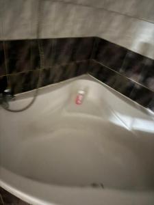 a white bath tub in a bathroom with a tile wall at Room in Mulhouse in Mulhouse