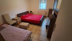 a small room with a red bed and a chair at Room in Mulhouse in Mulhouse