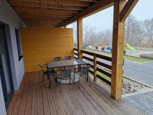 a wooden deck with a table and chairs on it at Apartamenty Dzika Orlica in Zieleniec