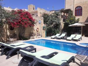 basen z leżakami obok budynku w obiekcie Dar ta'Zeppi Mansion w mieście Qala