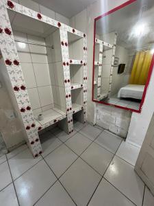 a small room with a mirror and a bed at Pousada Estilo Brasil in Fortaleza