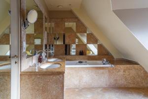 ein Badezimmer mit zwei Waschbecken und einer Badewanne in der Unterkunft L'Absinthe Hôtel in Honfleur