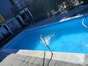 a swimming pool with a hose in the water at Altos de el bolson in El Bolsón