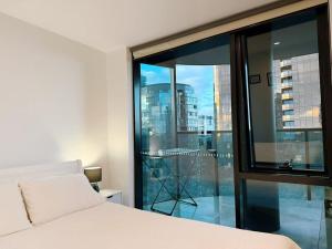 a bedroom with a bed and a large glass window at Prospect Box Hill - Magnificent View 2B1B in Box Hill +8 photos