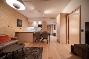 a living room and kitchen with a couch and a table at Levillas Lingonberry D26 in Levi