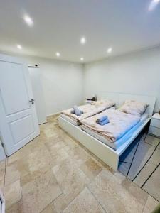 een witte kamer met 2 bedden en een deur bij Ferienwohnung auf dem Berg in Bad Bentheim