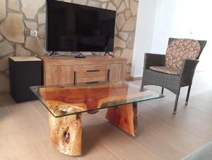 een woonkamer met een glazen tafel en een televisie bij La Casita in Tejadillos