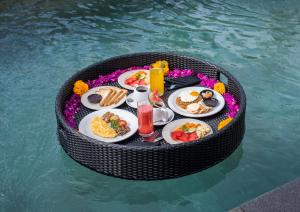 a circular table with food in a pool of water at Akar Villa in Ubud