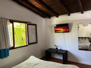 una camera da letto con un letto, una finestra e un tavolo di Altamare Villa Gesell a Villa Gesell