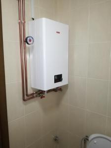 a toilet with a white tank in a bathroom at APARTMENT, PLJEVLJA, NEW BUILDING 71 m2 in Pljevlja