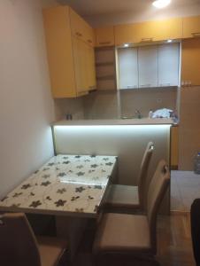a small kitchen with a table and chairs in it at APARTMENT, PLJEVLJA, NEW BUILDING 71 m2 in Pljevlja