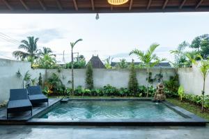een zwembad in de achtertuin van een huis bij Akar Villa in Ubud