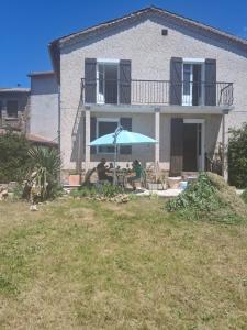 een blauwe paraplu voor een huis bij Chambres d'hôtes in Échandelys