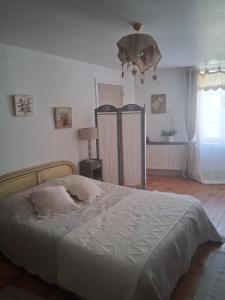 een slaapkamer met een groot bed en een lamp bij Chambres d'hôtes in Échandelys