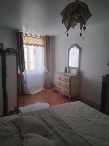 een slaapkamer met een bed, een dressoir en 2 ramen bij Chambres d'hôtes in Échandelys