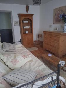 een slaapkamer met 2 bedden en een houten dressoir bij Chambres d'hôtes in Échandelys