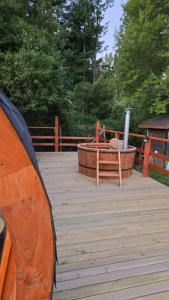a wooden deck with a hot tub and a bench at Tiny House in Trape