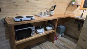 a kitchen with a microwave on a wooden counter at Tiny House in Trape