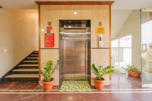 an elevator in a building with two potted plants at Treebo Akshaya Palace Inn in Mysore
