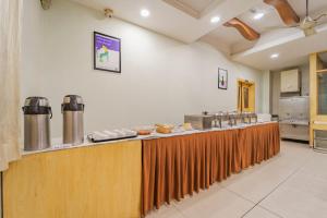 a kitchen with a long counter with food on it at Treebo Akshaya Palace Inn in Mysore