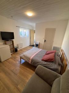 ein Schlafzimmer mit einem Bett und einer Couch in der Unterkunft Chez Carla in Sisteron